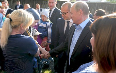 Президент России Владимир Путин общается с жителями во время посещения аварийного жилья семьи Анастасии Вотинцевой в Ижевске