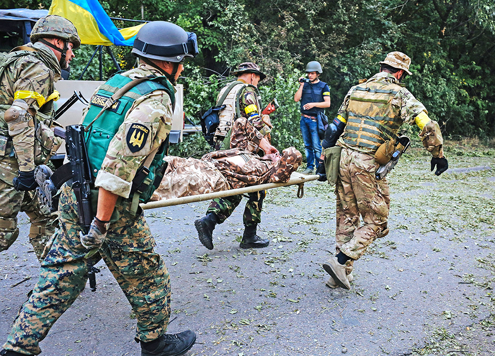  Украинские военные выносят раненых с передовой