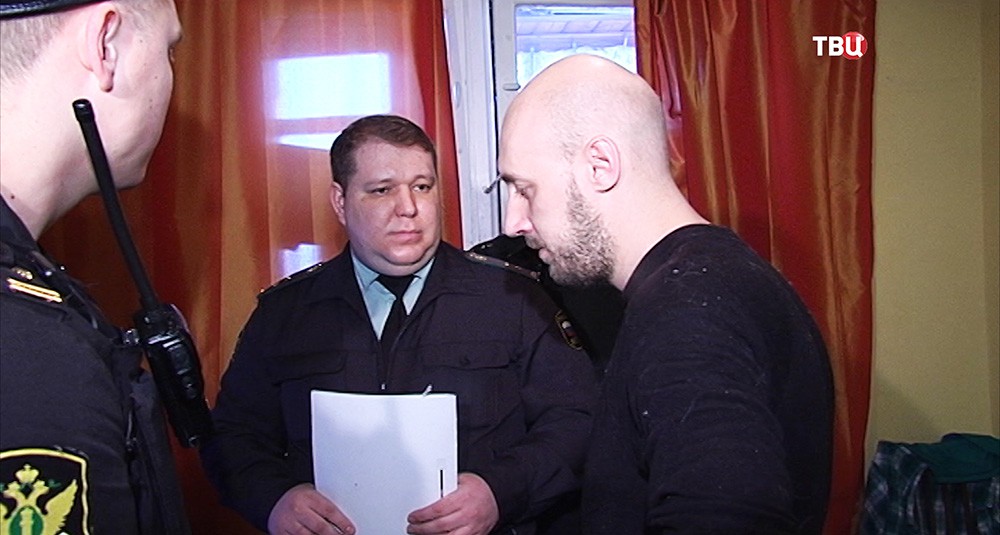 Житель квартиры, имеющий задолжность, беседует с судебным приставом Житель квартиры, имеющий задолжность, беседует с судебным приставом
