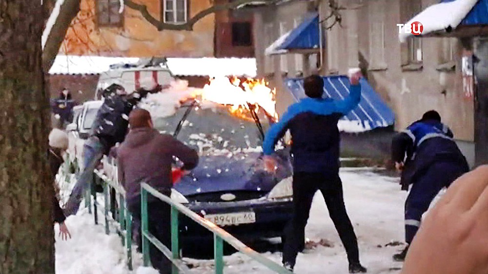 Люди тушат горящую машину Люди тушат горящую машину