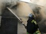 Сотрудник пожарной службы МЧС во время тушения пожара Сотрудник пожарной службы МЧС во время тушения пожара
