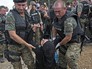Европейские полицейские несут пострадавшую мигрантку Европейские полицейские несут пострадавшую мигрантку