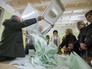 Члены избирательной комиссии считают голоса на избирательном участке Члены избирательной комиссии считают голоса на избирательном участке