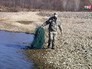 Инспектор Росрыболовства несет найденную сеть браконьеров Инспектор Росрыболовства несет найденную сеть браконьеров