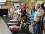 Пассажиры в аэропорту получают багаж Пассажиры в аэропорту получают багаж