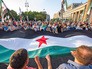 Люди растянули флаг Сирии Люди растянули флаг Сирии
