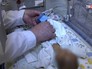 Врач осматривает новорожденную Врач осматривает новорожденную
