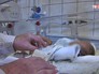 Врач осматривает новорожденную Врач осматривает новорожденную