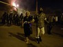 Мужчина уводит пожилую женщину с места столкновения протестующих с полицейскими на улице близ захваченного в Ереване здания полка патрульно-постовой службы Мужчина уводит пожилую женщину с места столкновения протестующих с полицейскими на улице близ захваченного в Ереване здания полка патрульно-постовой службы