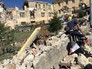 Люди у разрушенных в результате землетрясения домов в городе Аматриче Люди у разрушенных в результате землетрясения домов в городе Аматриче