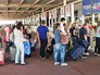 Пассажиры в очереди на стойках регистрации в аэропорту Пассажиры в очереди на стойках регистрации в аэропорту