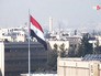 Флаг Сирии на фоне города Флаг Сирии на фоне города