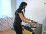 Женщина греет воду на плите Женщина греет воду на плите