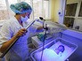 Врачи обследуют новорожденного ребенка Врачи обследуют новорожденного ребенка