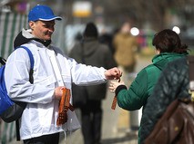 Волонтёр раздаёт георгиевские ленточки на Зубовском бульваре