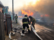 Сотрудники МЧС тушат горящие дома
