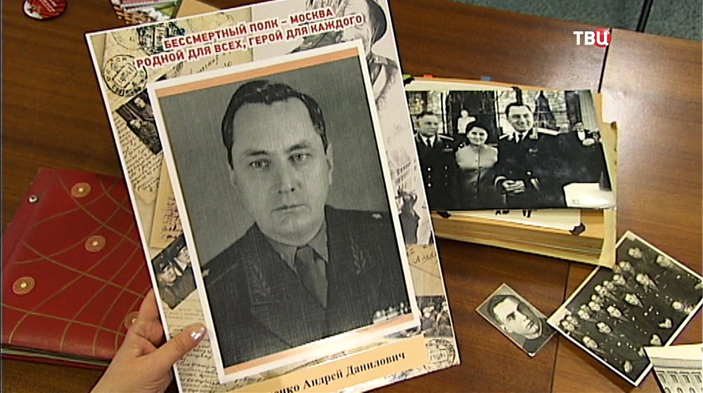 Участница акции "Бессмертный полк" демонстрирует фотографию своего деда