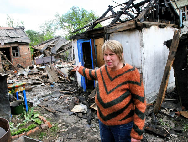 Жительница пригорода Донецка во дворе жилого дома, разрушенного в результате обстрелов украинскими силовиками