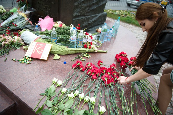 Люди возлагают цветы к памятнику жертвам трагедии в Беслане