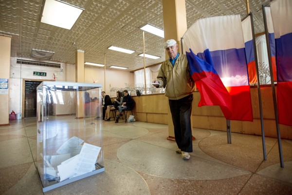 Избиратель голосует на избирательном участке
