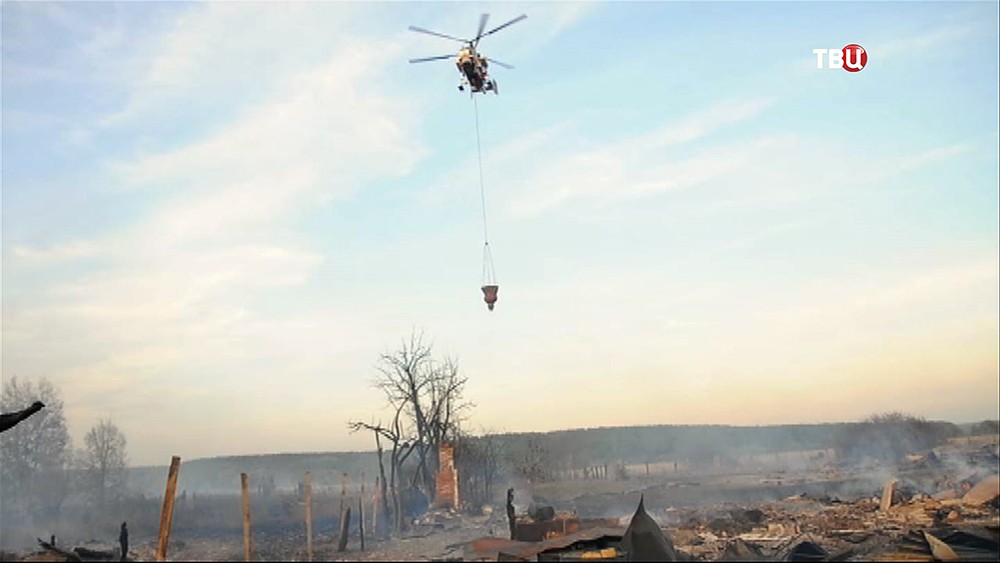 Пожарный вертолёт на месте возгорания в посёлке