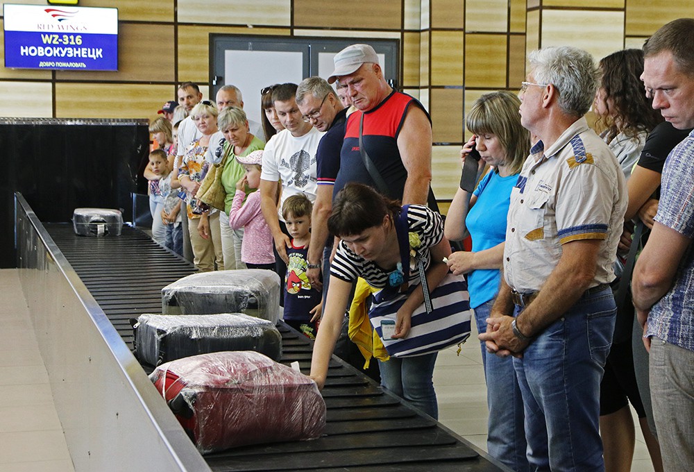 Пассажиры в аэропорту получают багаж 