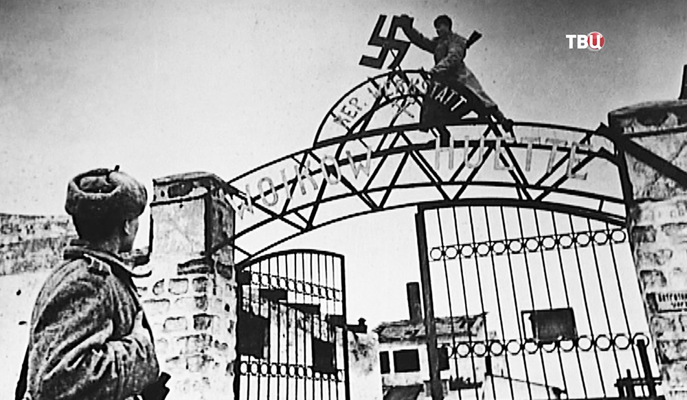 Советские солдаты снимают фашистский крест с ворот концлагеря
