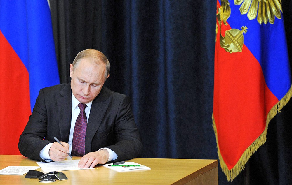 Президент России Владимир Путин подписывает указ