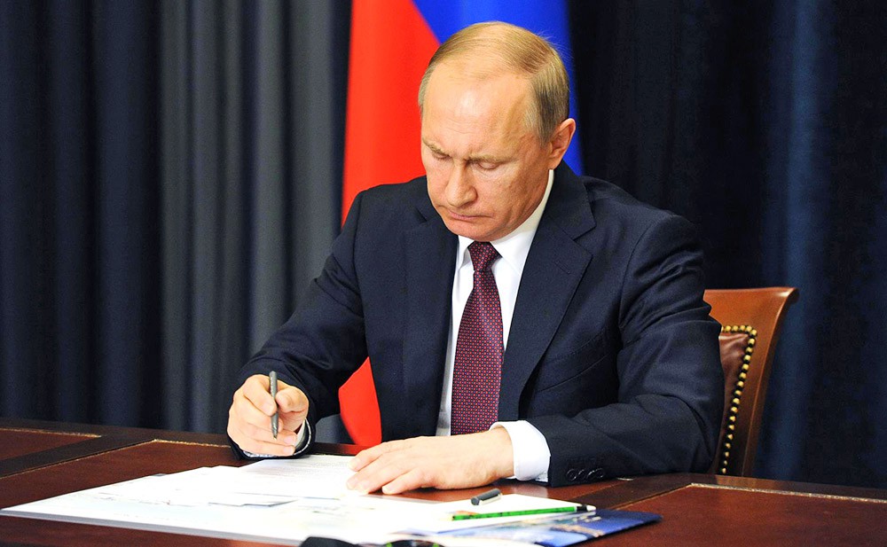 Президент России Владимир Путин подписывает закон