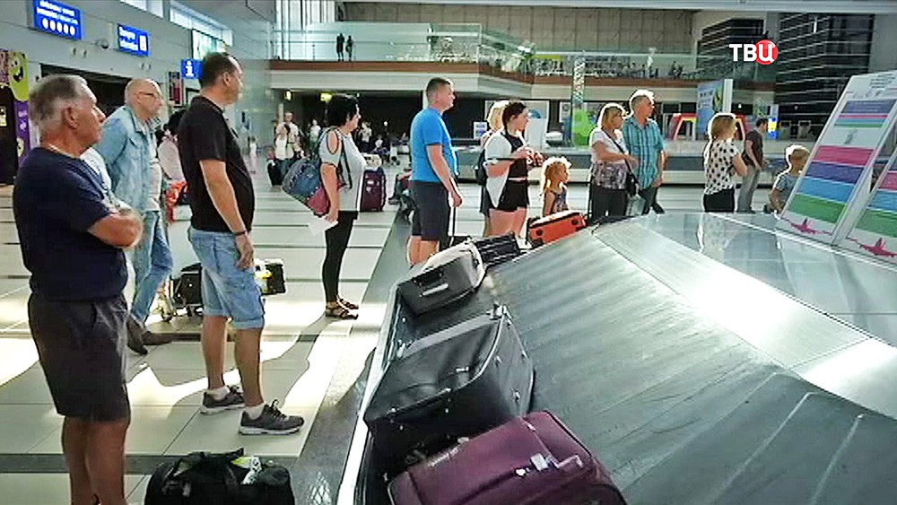 Пассажиры получают багаж в аэропорту