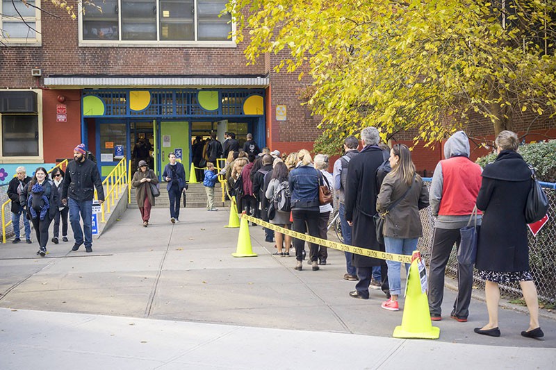 Горожане стоят в очереди на избирательный участок в Нью-Йорке, где проходит голосование на выборах президента США