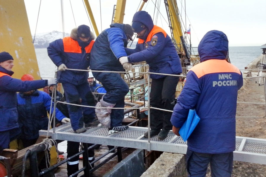 Сотрудники МЧС эвакуируют пострадавших рыбаков с траулера "Новоульяновск"