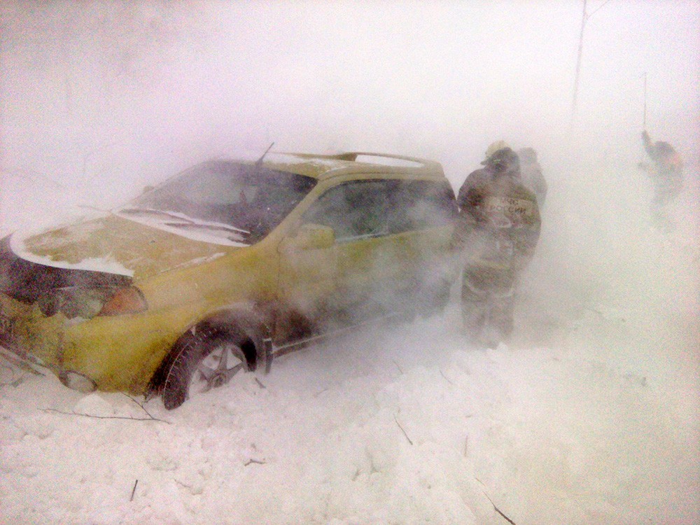 Спасатели МЧС работают во время снежного бурана на трассе