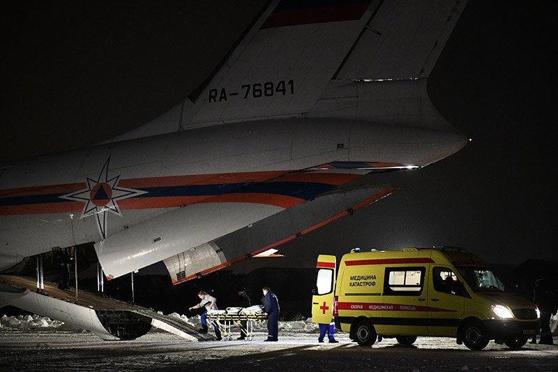 Сотрудники медицинской службы выгружают из самолета МЧС России детей