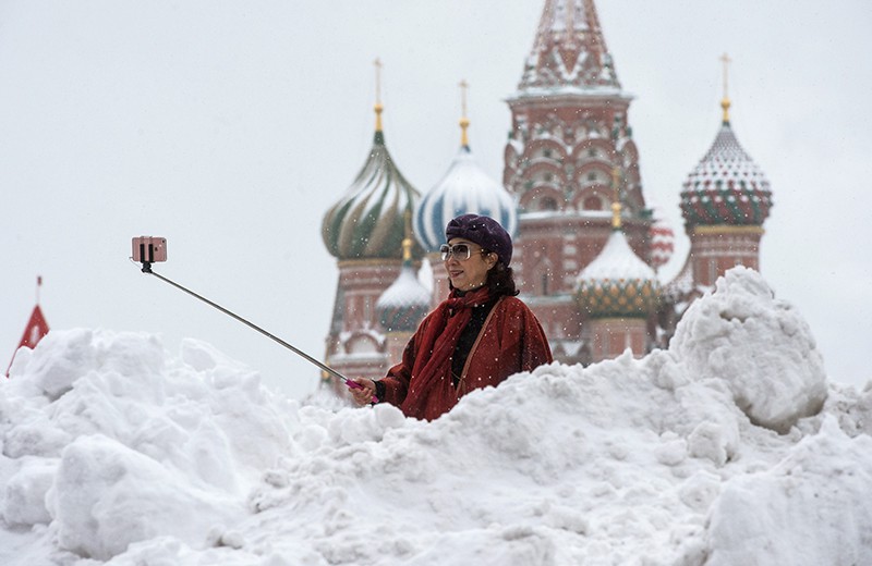 Женщина фотографируется у храма Василия Блаженного на Красной площади