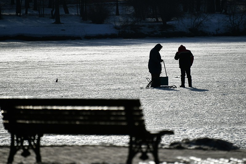 Рыбаки на льду пруда 