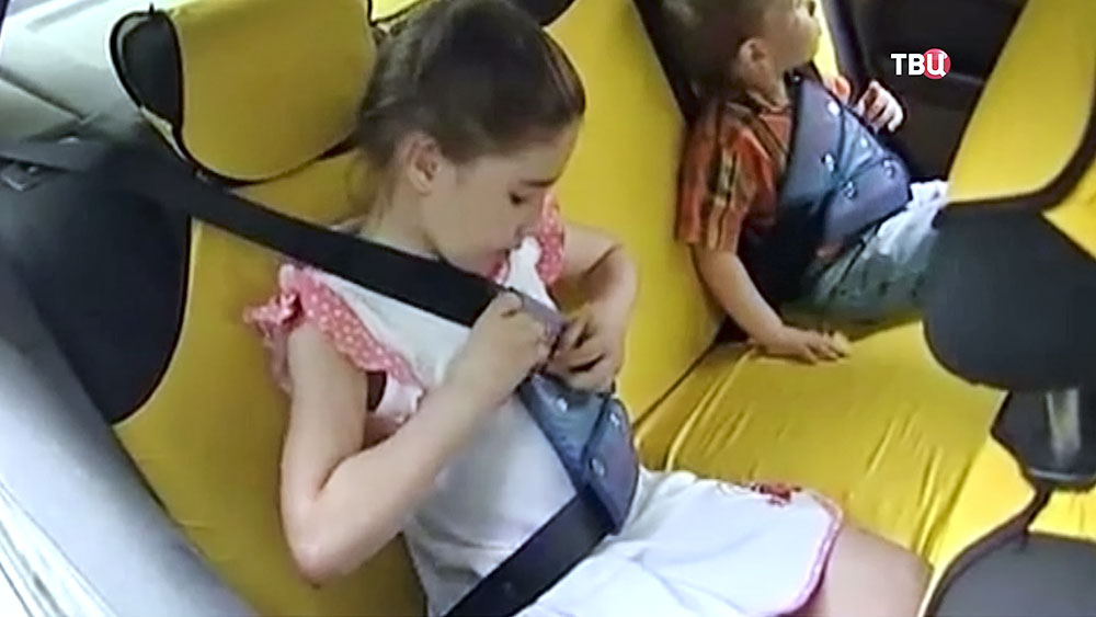 Дети пристегиваются в машине