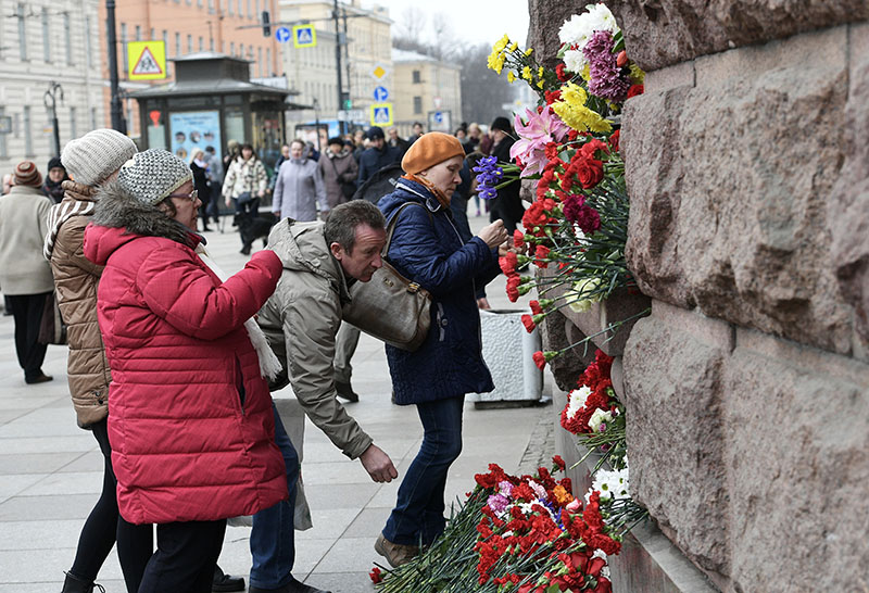 Люди возлагают цветы у станции метро "Технологический институт", где накануне произошел взрыв