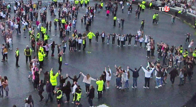 Полицейские Великобритании пляшет вместе со зрителями на концерте