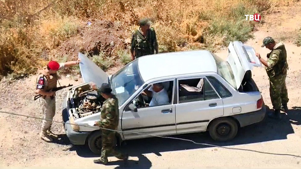 Военная полиция МО России осматривает машину на КПП в Сирии 