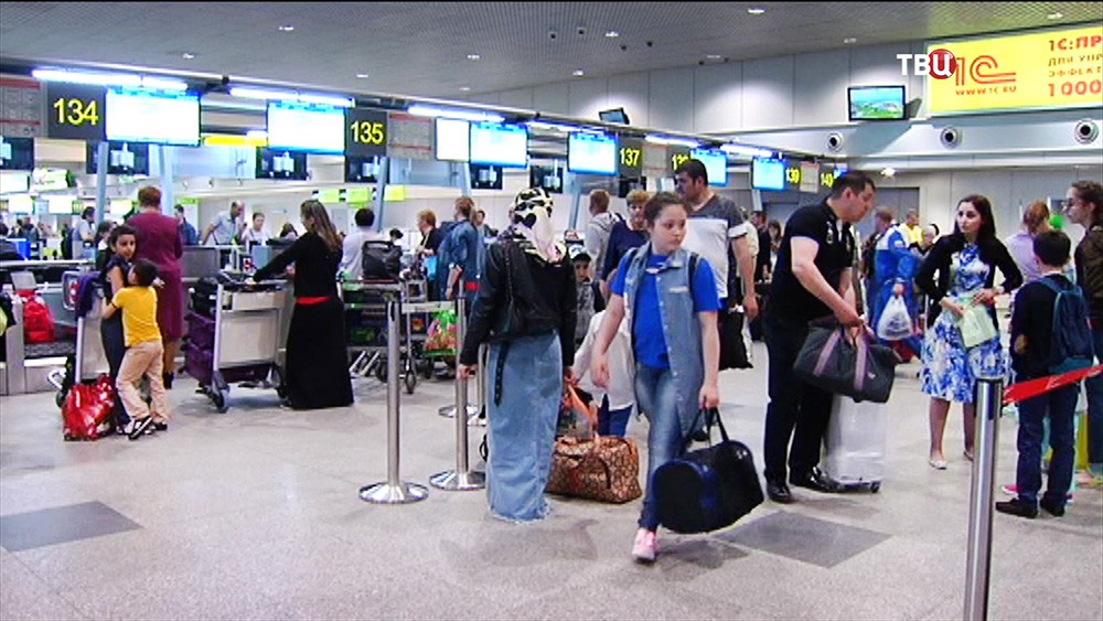 Пассажиры на стойке регистрации в аэропорту