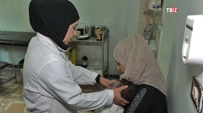 Сирийские врачи осматривают ребенка 
