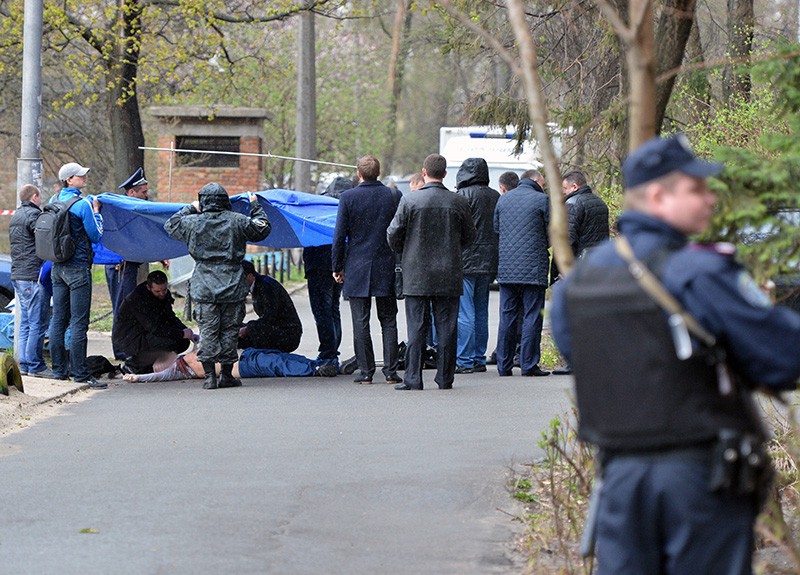 Криминалисты и работники полиции работают на месте убийства журналиста-оппозиционера Олеся Бузины в Киеве