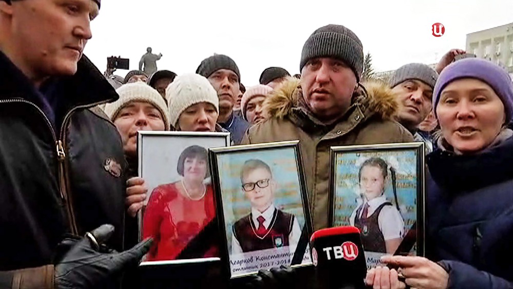 Жители Кемерова держат фотографии детей погибших в пожаре в торговом центре