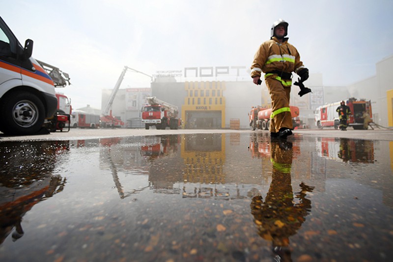 Сотрудники МЧС и пожарная техника перед зданием торгового центра "Порт" в Казани, где произошло возгорание