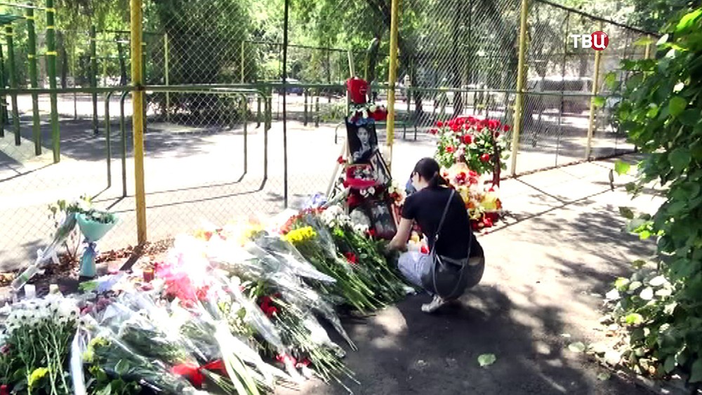 Люди возлагают цветы на месте гибели Дениса Тена