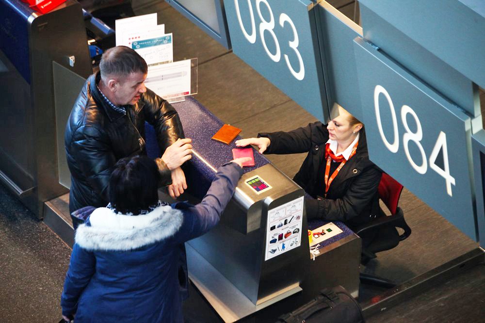 Пассажиры на стойке регистрации в аэропорту
