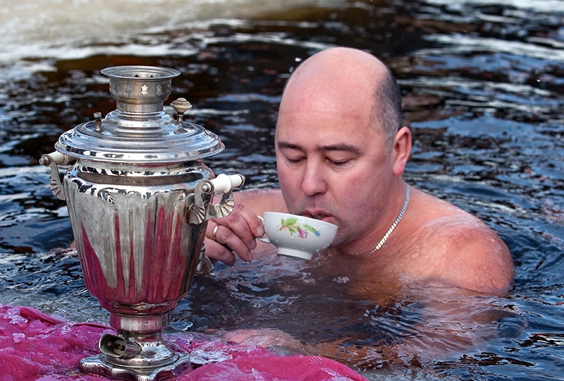 Мужчина пьет чай в проруби