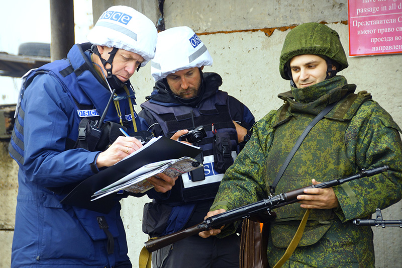 Наблюдатели ОБСЕ (слева) следят за отводом сил бойцов подразделений ЛНР в поселке Золотое в Луганской области