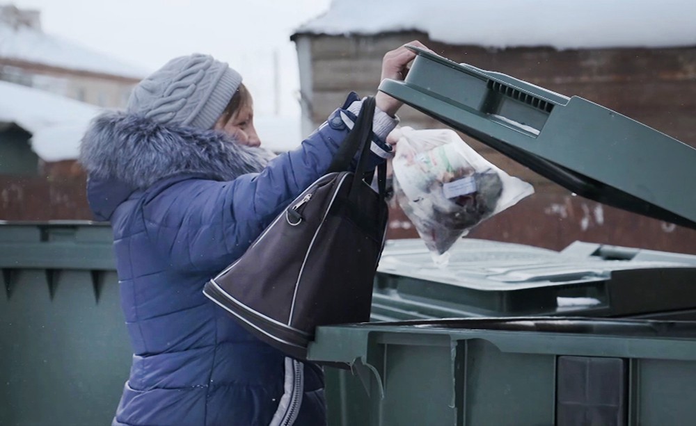 Женщина вбрасывает мусор